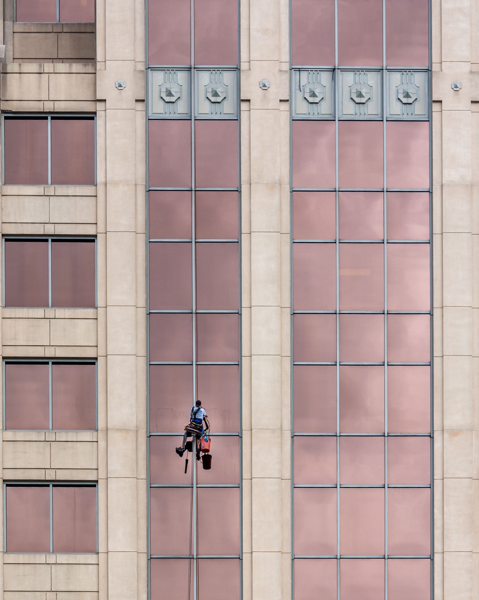 Window cleaner descending a commercial building facade