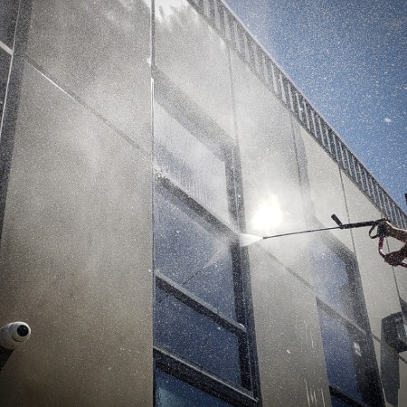 Pressure washing spray on a commercial building