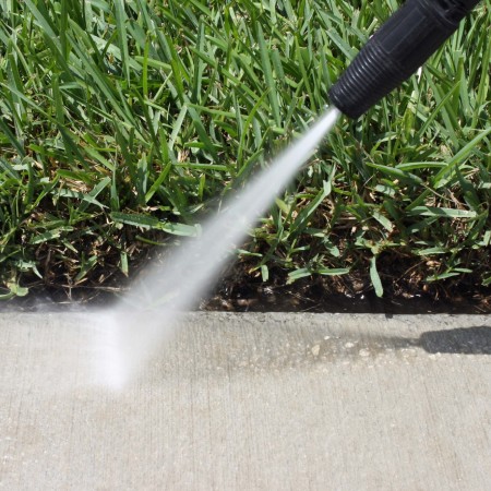 Pressure washing spray on an outdoor surface