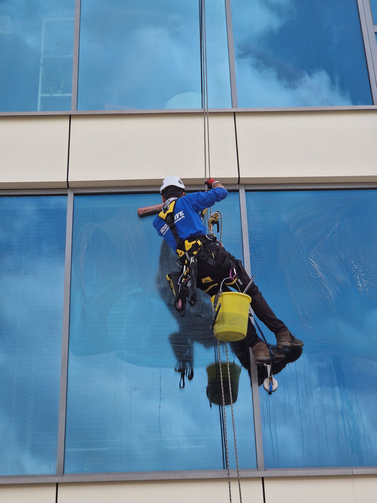 Technician cleaning a high-rise glass facade