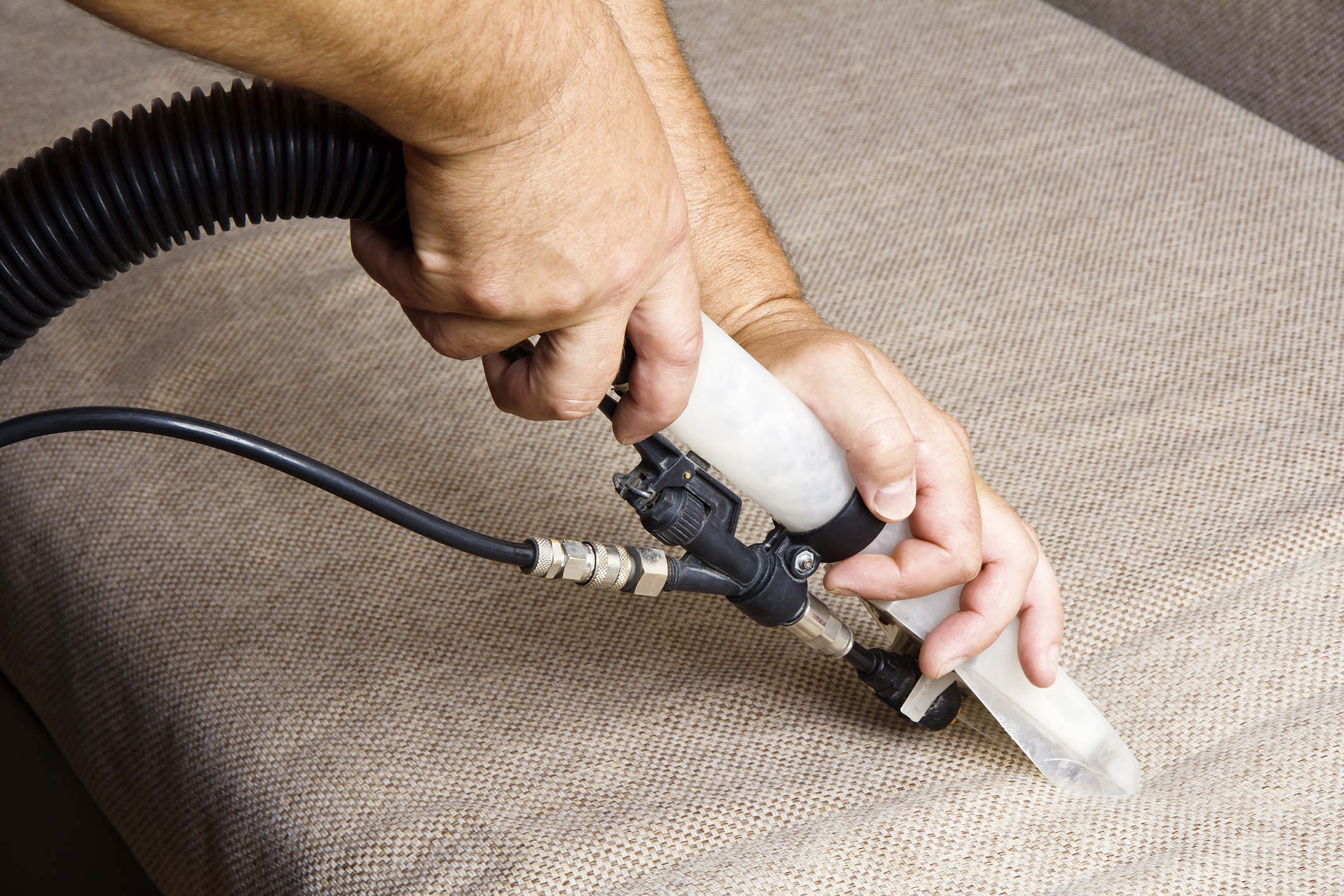 Professional upholstery cleaning wand on fabric